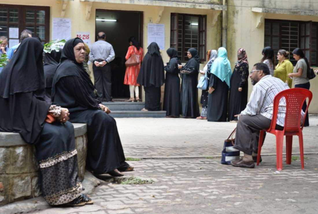 Indian voters queue to cast their ballots in the Karnataka Legislative Assembly Elections at a polling station in Bangalore on May 12, 2018