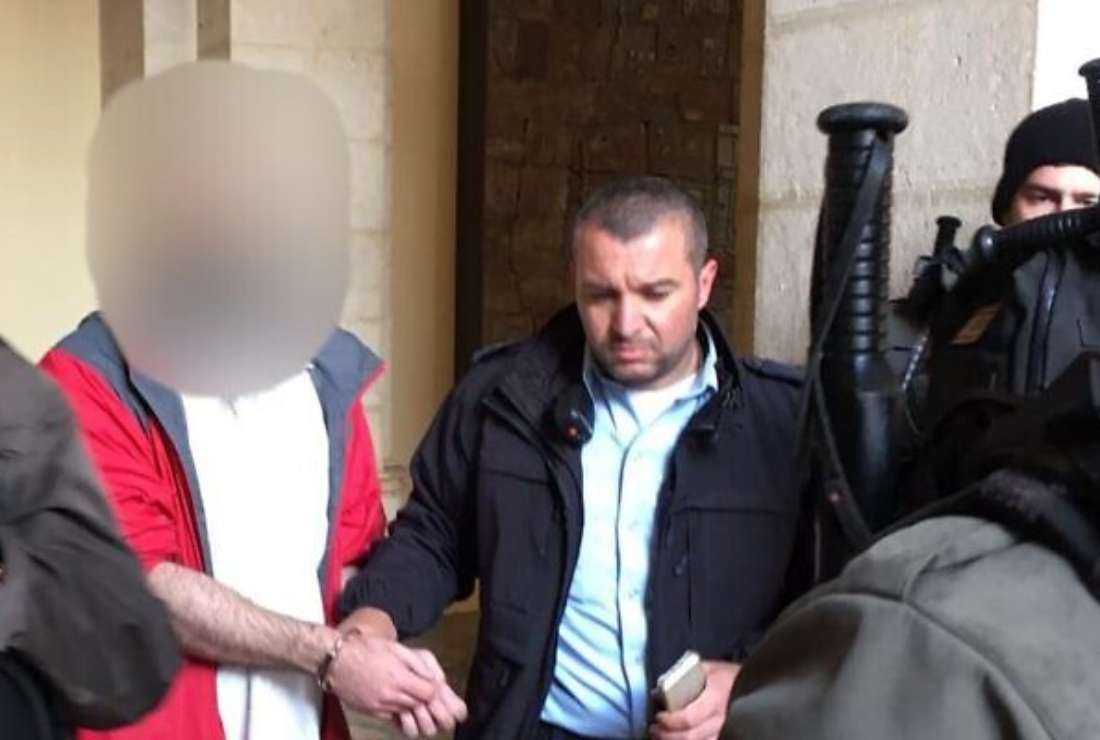 A US tourist, left, is led away by police on suspicion that he vandalized a statue in the Church of the Flagellation in the Old City of Jerusalem, Feb. 2