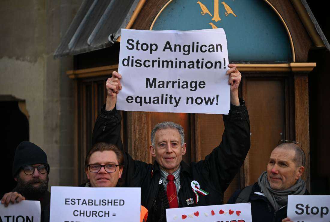 British gay rights activist Peter Tatchell (center) stands with Pro-LGBT+ activists as they take part in a demonstration outside of Church House, in London, on Feb. 8, 2023, on day three of the Church of England's General Synod