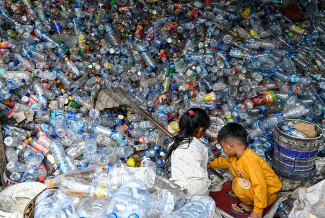 Indonesian children play with plastic bottles at a waste collection site in Banda Aceh on Oct. 28, 2022