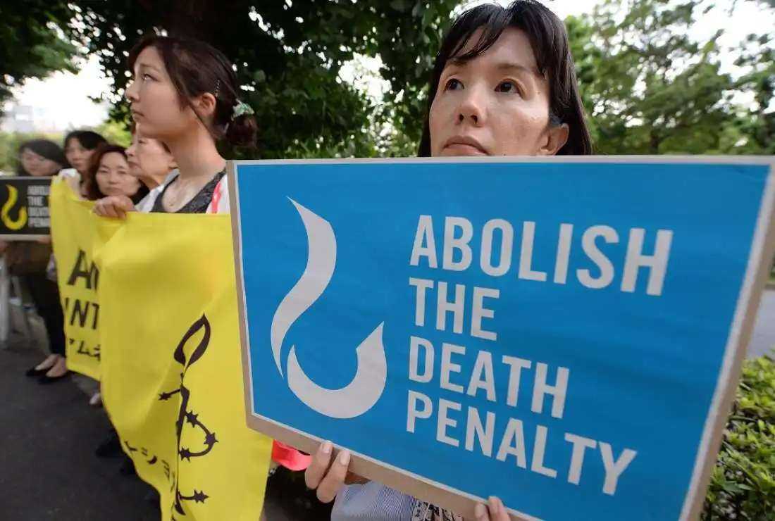 Members of civic groups hold banners denouncing the death penalty during a demonstration in front of the Justice Ministry in Tokyo on June 26, 2014