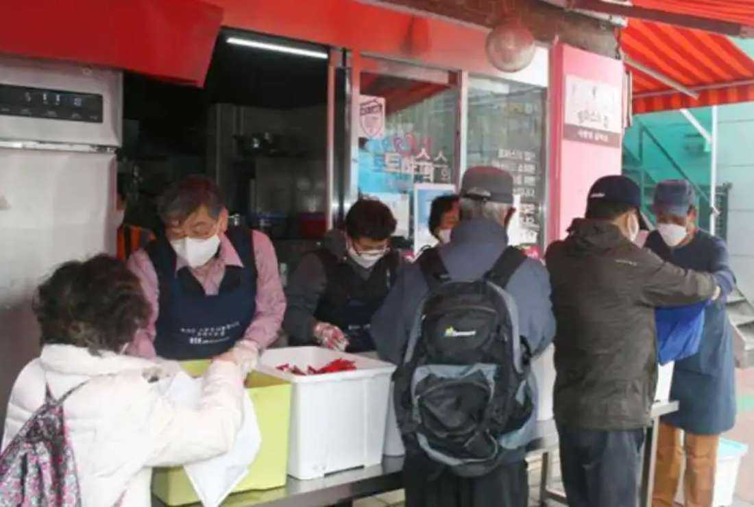 Poor people receive free lunch boxes from volunteers at Thomas House in South Korean capital Seoul