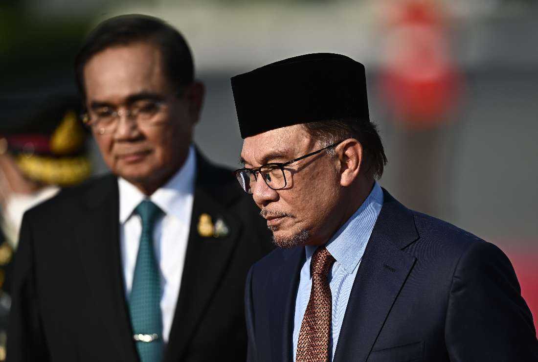 Malaysia's Prime Minister Anwar Ibrahim (right) and Thailand's Prime Minister Prayut Chan-O-Cha (left) inspect a guard of honor during an official state visit at the Government House in Bangkok on Feb. 9