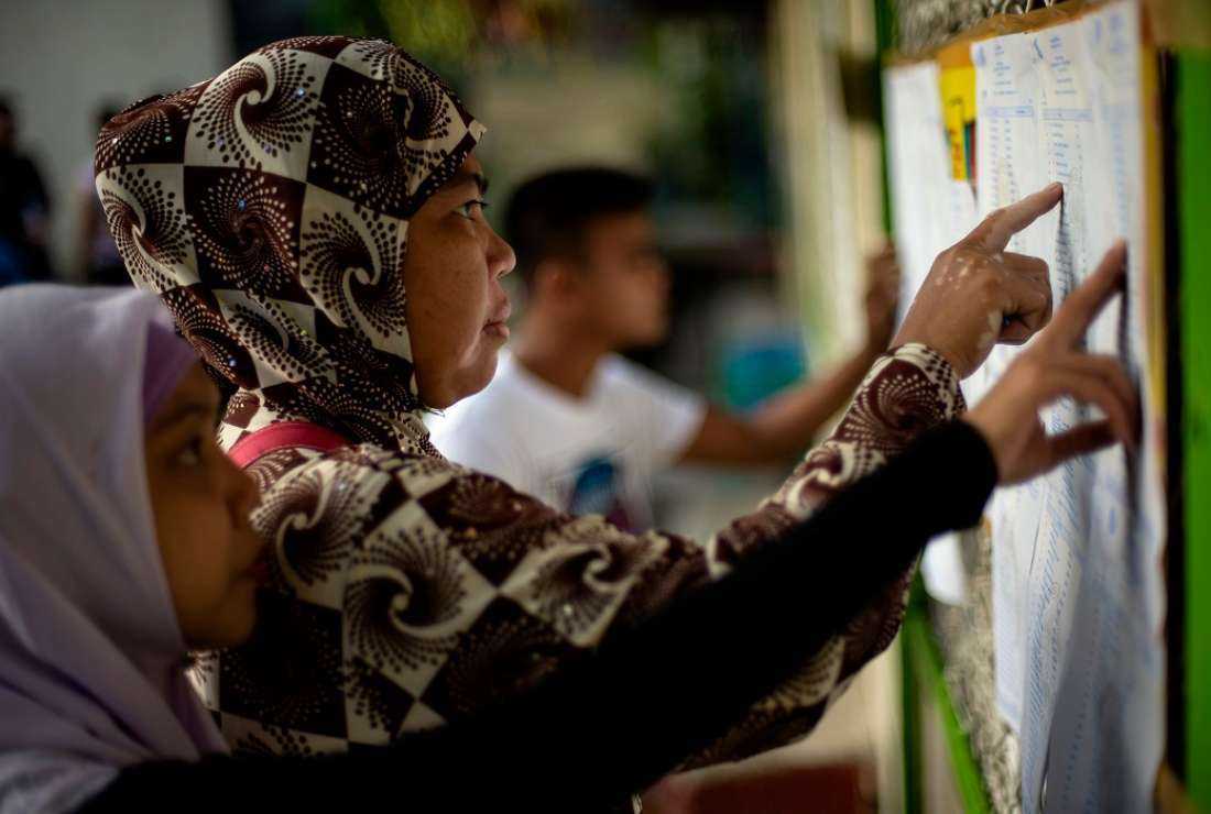Muslim women look for their names at a voting precinct in Maguindanao, on the southern island of Mindanao on Jan 21, 2019, for a plebiscite to ratify the passage of the Bangsamoro Organic Law (BOL). A decades-long push to halt violence that claimed some 150,000 lives in the southern Philippines culminated with a vote on giving the nation's Muslim minority greater control over the region