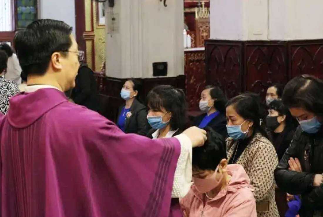 Vicar-general Father Anthony Nguyen Van Thang places ash on the heads of the faithful in Hanoi Cathedral on Ash Wednesday on Feb. 17, 2021