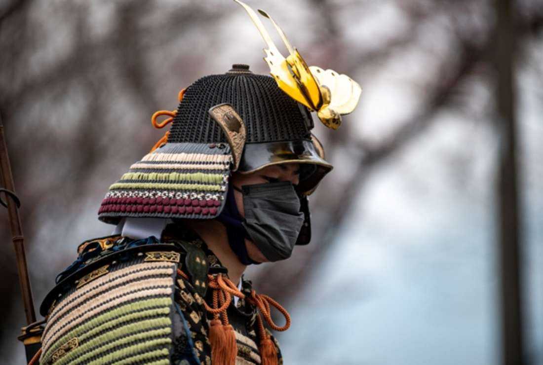 A horseman wearing samurai armor and a face mask attends a ceremony at Hibarigahara Festival Site, during the last leg of the first day of the Tokyo 2020 Olympic torch relay in Minamisoma, Fukushima Prefecture on March 25, 2021