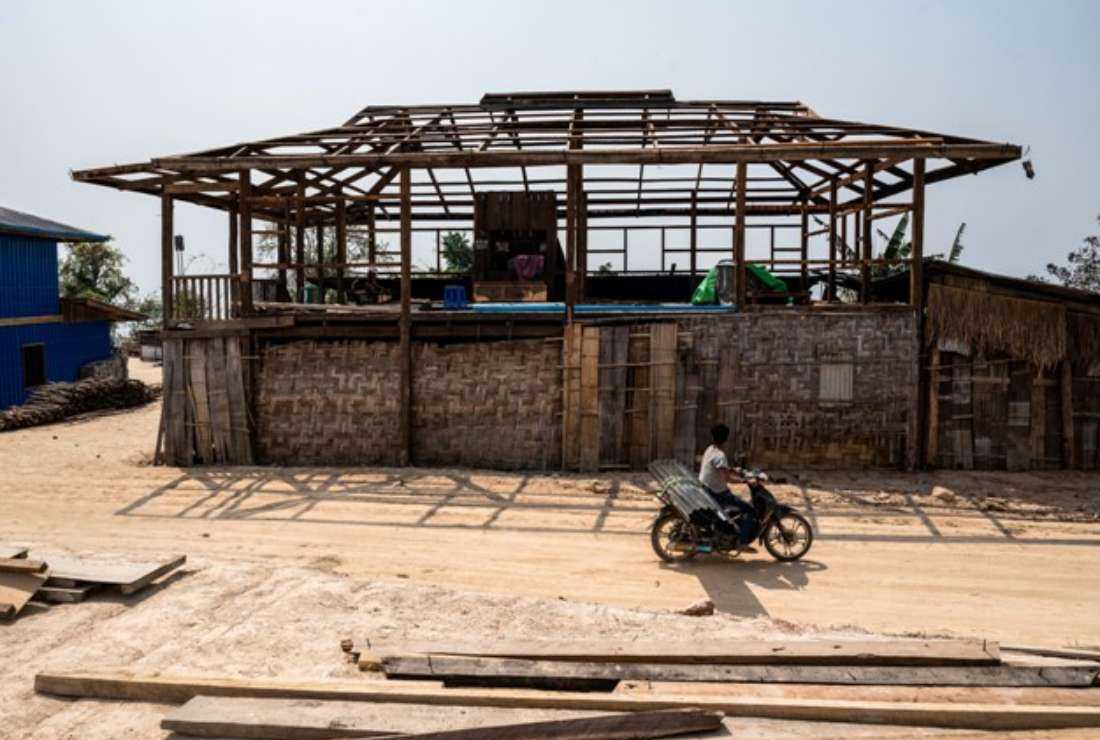 In this photo taken on March 9, a villager rides past a house damaged following air strikes by Myanmar’s military at Kone Tar Village, Namhsan Township in Myanmar's northern Shan State