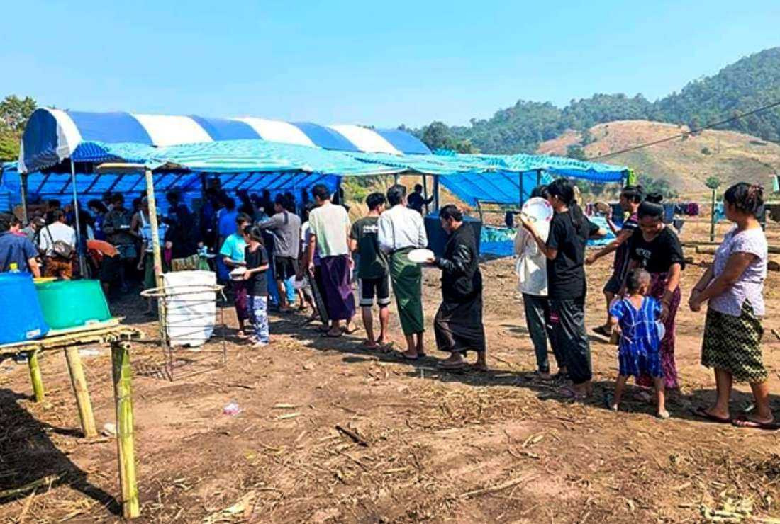 People fleeing due to fighting between the military and the Karen National Union (KNU) line up to receive food at a temporary lodging for internally displaced people (IDPs) in Karen state, along the Thai-Myanmar border, on Dec. 25, 2021