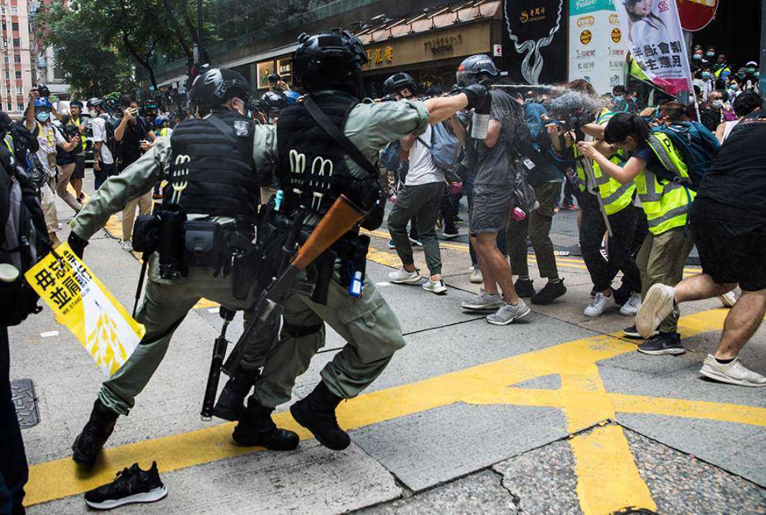Riot police pepper spray a group of journalists in Hong Kong on July 1, 2020