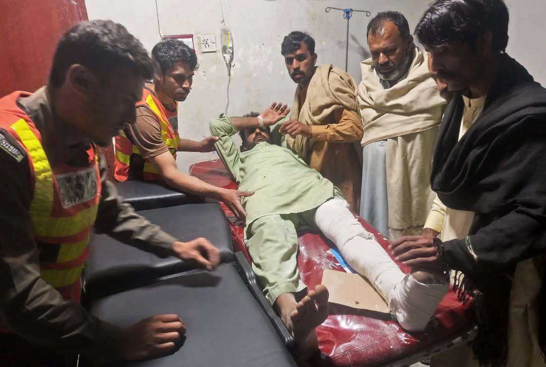 This handout photograph released by Pakistan's Emergency Rescue 1122 Service on March 22 shows rescue workers attending an earthquake victim at a hospital in Swat of Khyber Pakhtunkhwa province