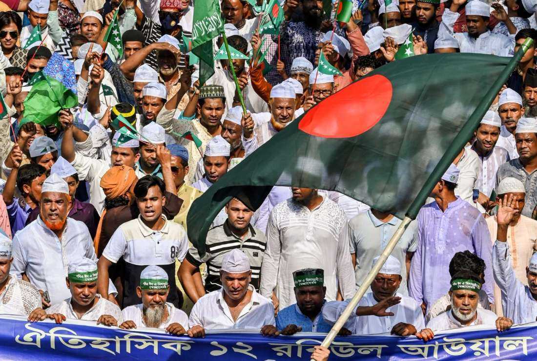 Muslim devotees carry a Bangladesh national flag as they take part in a rally to mark Eid-e-Milad-un-Nabi, the birthday of the Prophet Mohammad, in Dhaka on October 9, 2022. Minority Ahmadi Muslims have endured violence from radicals in the past decades