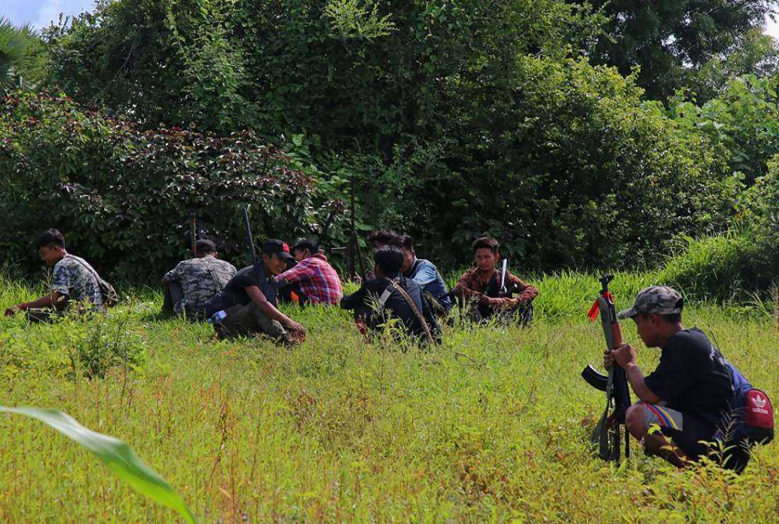 This photo taken on Aug. 10, 2022, shows anti-coup fighters with their weapons sitting in a field in Myanmar's northwestern Sagaing region