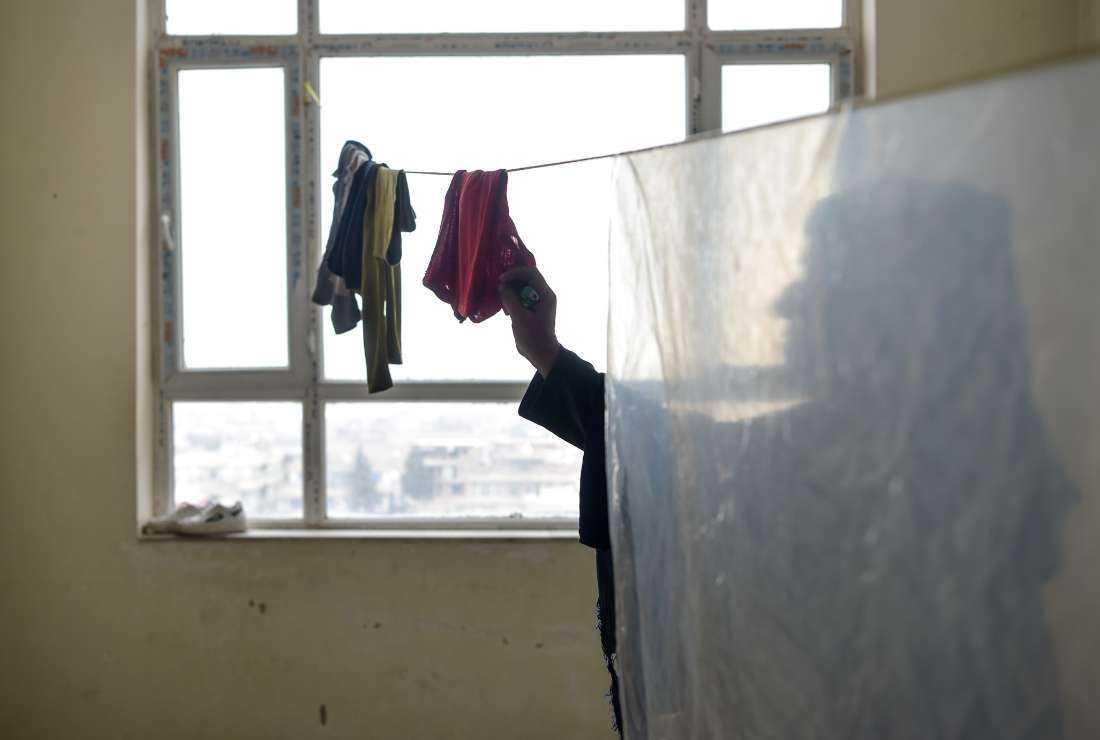 In this photo taken on Feb. 1, Marwa, a divorced woman whose name has been changed for her protection, hangs up clothes to dry during an interview with AFP at a house in an undisclosed location in Afghanistan
