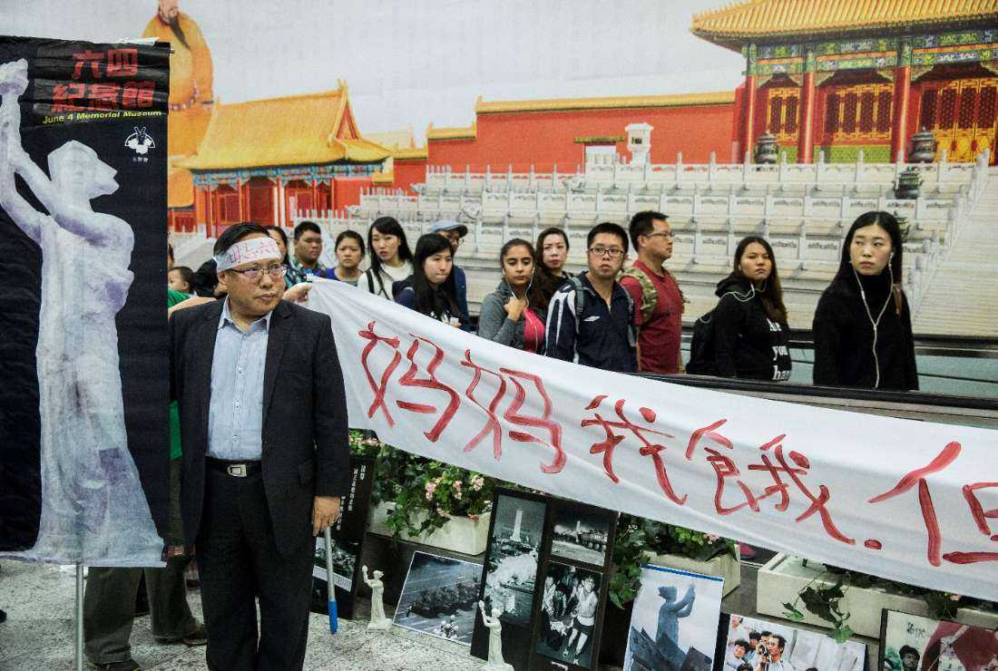 In this file photo taken on January 9, 2017, Albert Ho, politician and chairman of the Hong Kong Alliance in Support of Patriotic Democratic Movements in China, participates in a protest against the 1989 Tiananmen Square crackdown beside an advertisement for the controversial Hong Kong Palace Museum in Hong Kong