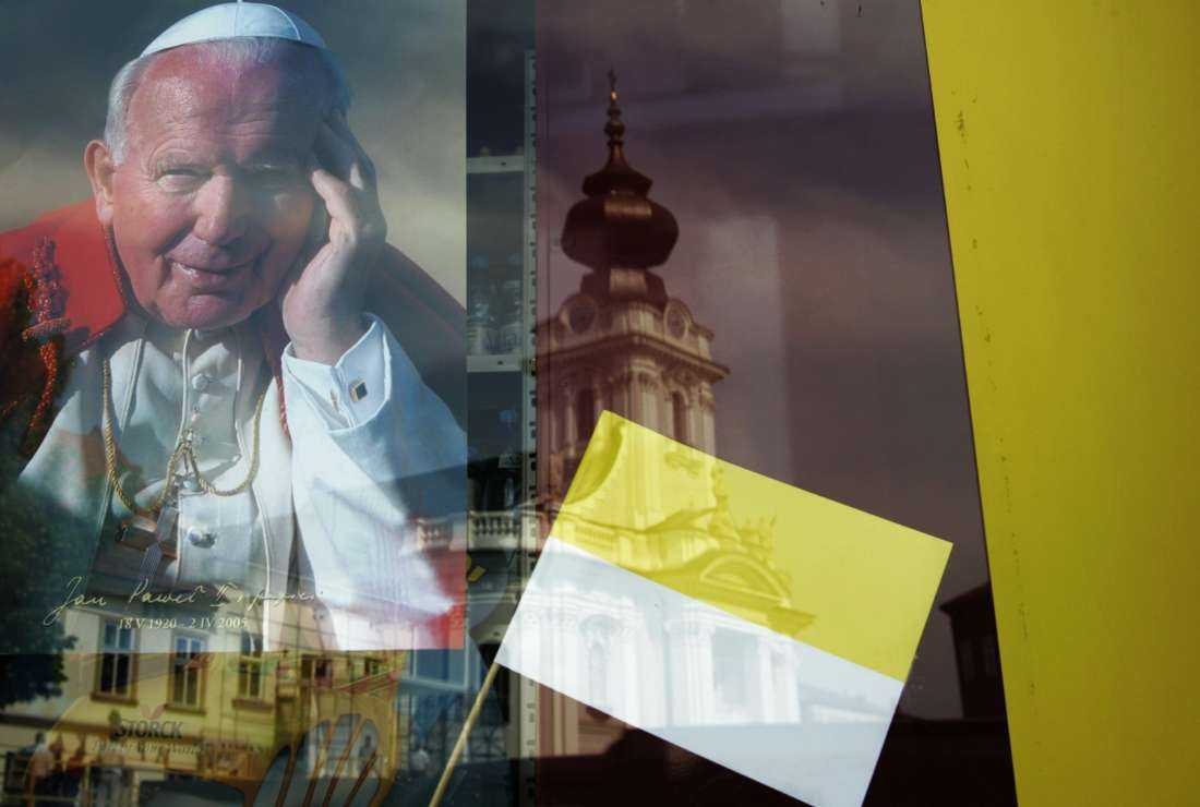 This file photo taken on May 23, 2006, shows the Basilica of the Presentation of Virgin Mary church where the late John Paul II (Karol Wojtyla) was baptized being reflected on a shop window where a picture of the late pope is displayed in Karol Wojtyla's home town of Wadowice