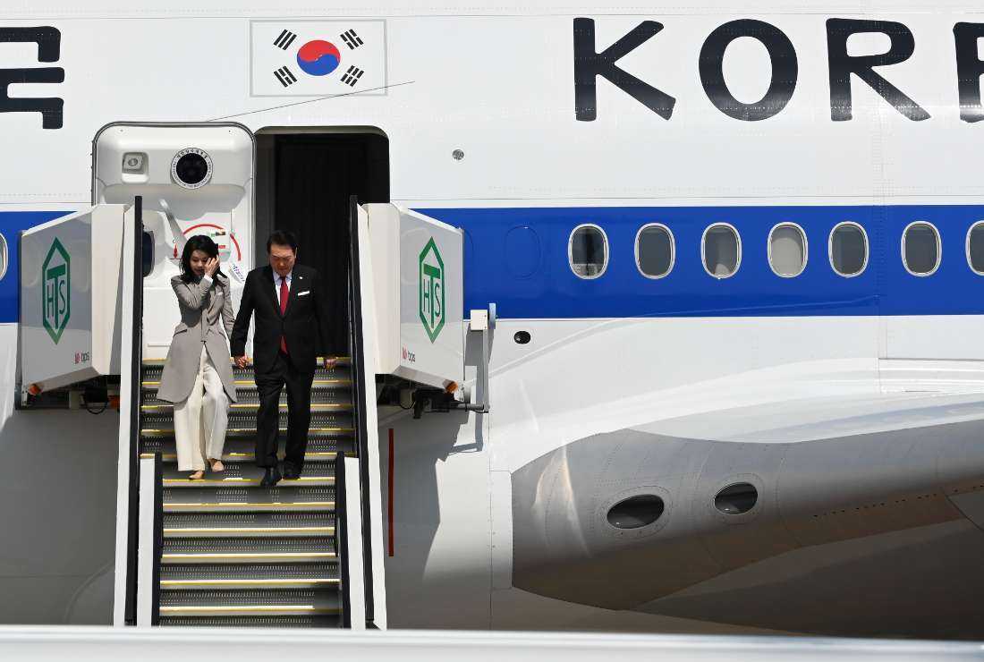 South Korea's President Yoon Suk Yeol (right) and his wife Kim Keon Hee disembark from the aircraft upon their arrival at Tokyo's Haneda Airport on March 16