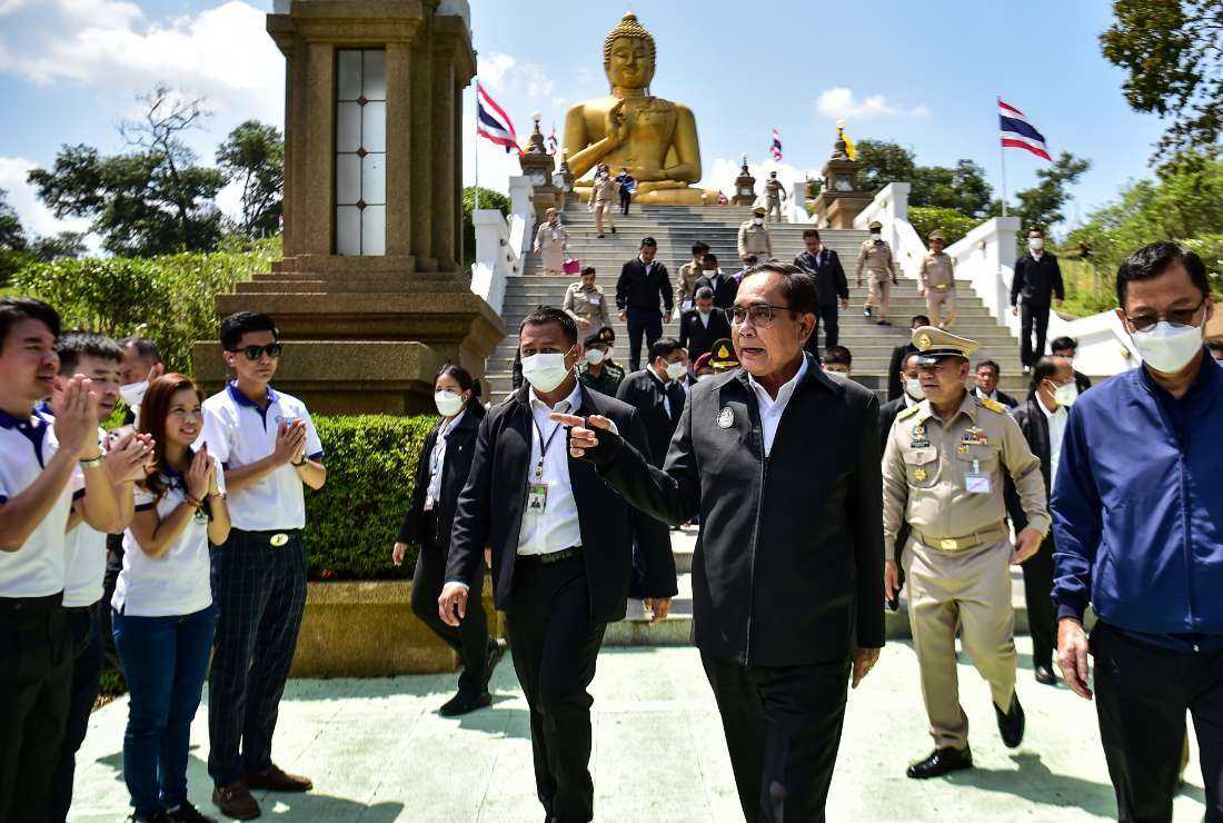 Thailand's Prime Minister Prayut Chan-O-Cha (third from right) walks in front of the Golden Buddha statue as he visits Khao Kong temple in Narathiwat district, southern Thailand, on March 15