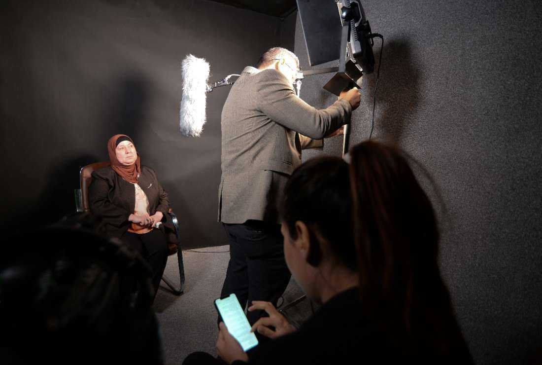 An Iraqi woman prepares to share her memories of what she endured under the Islamic State (IS) group, during a filmed interview with members of the Mosul Eye project, in Mosul on Feb. 27