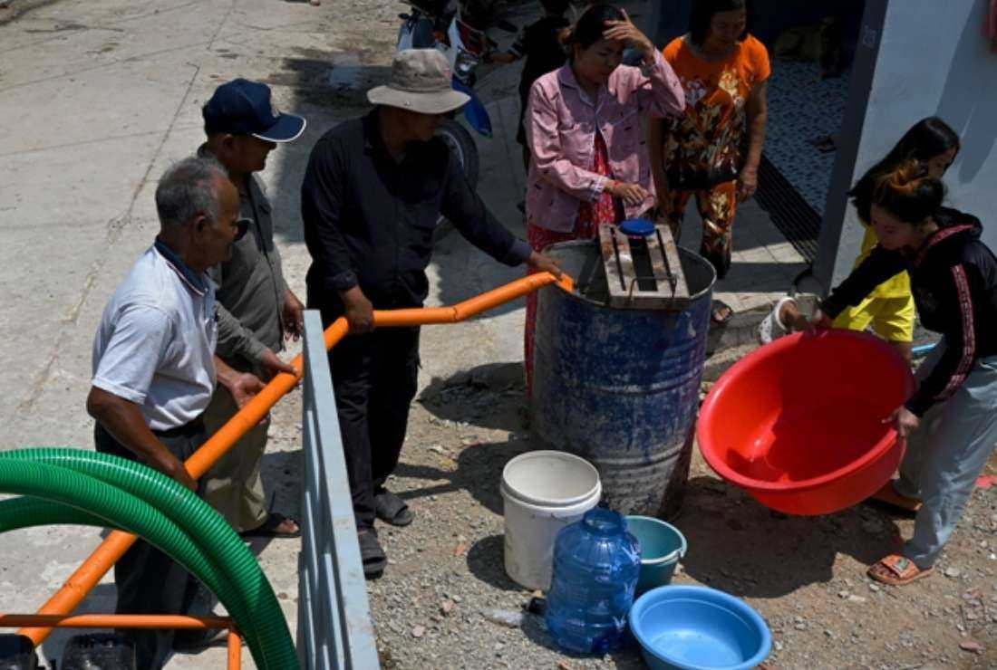 Local municipal workers distribute water to villagers in Kouk Roka commune on the outskirts of Phnom Penh in Cambodia on March 27
