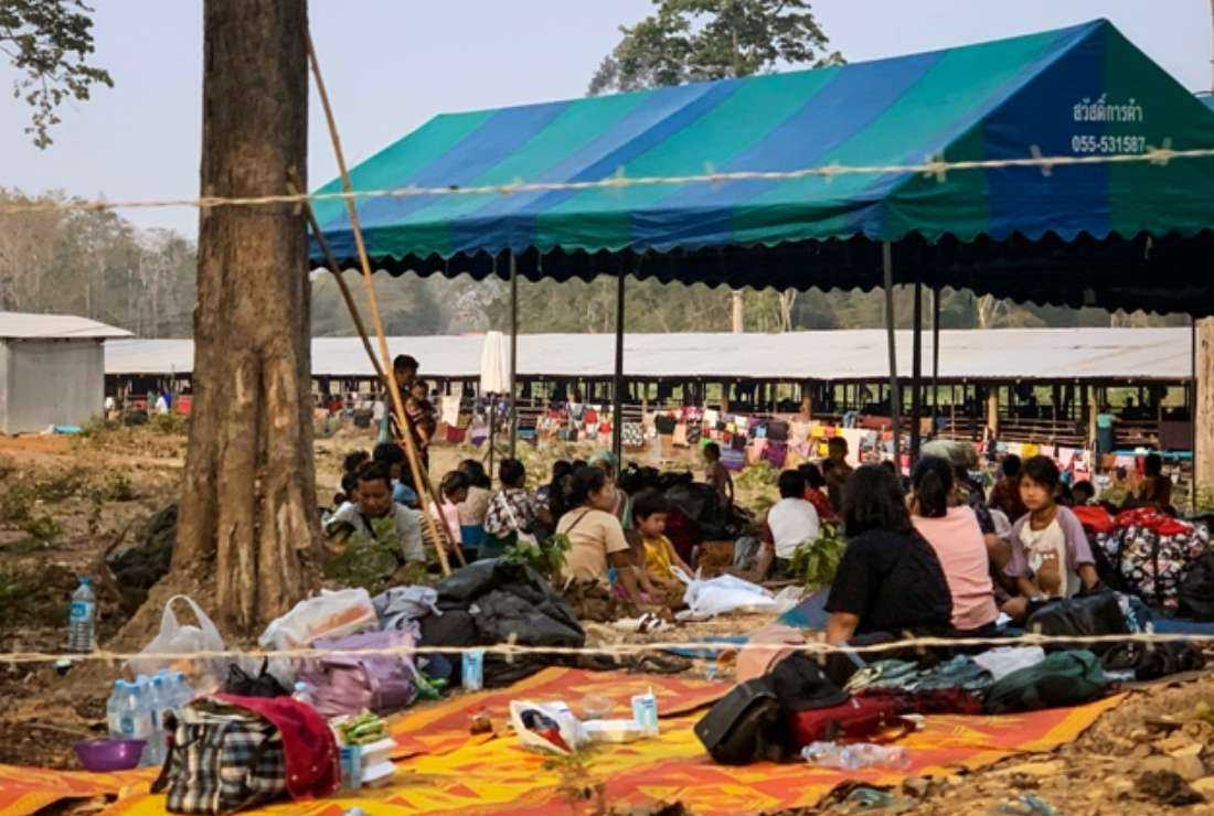 People fleeing fighting between the Myanmar military and ethnic rebel groups shelter on the Thai side of the Moei River, in Mae Sot district in Tak province on April 7. Thousands of people have fled to Thailand following fierce fighting between Myanmar rebels and the military, Thai officials said on April 6
