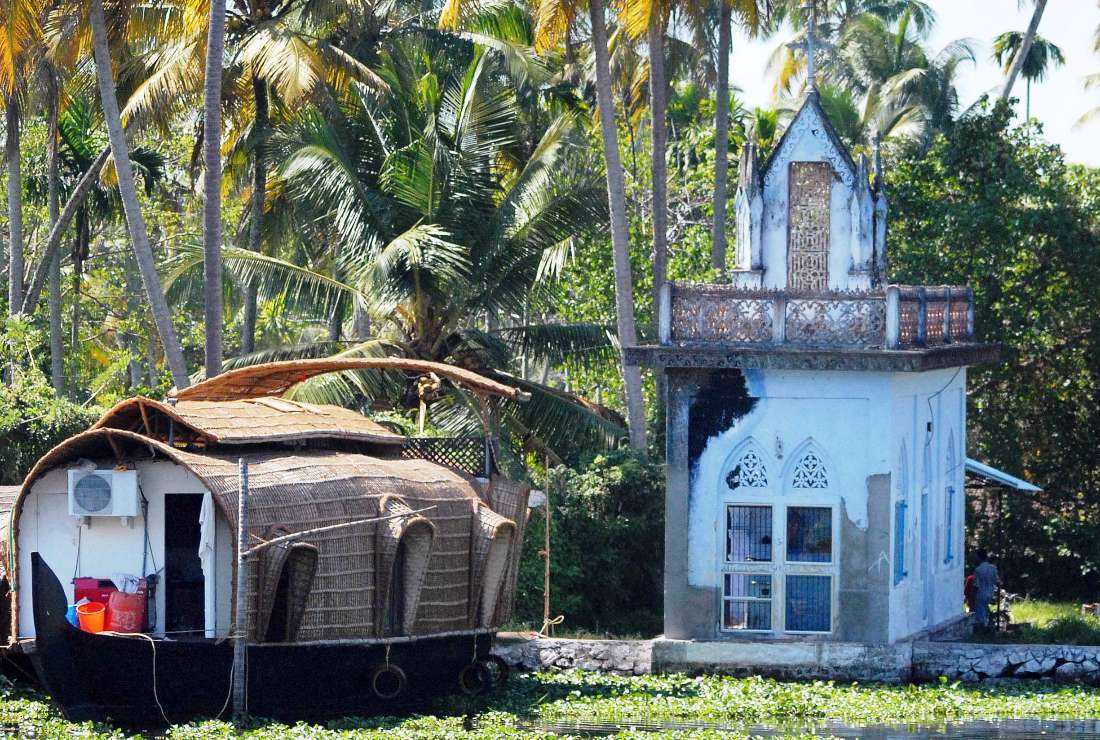 This photo taken Dec. 29, 2006, shows a houseboat anchored beside a church in the backwaters of Alappuzha, some 150 kilometers north of Thiruvananthapuram, capital of India's southern state of Kerala