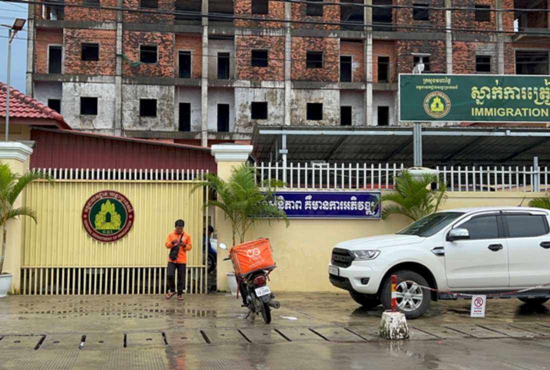 This photo taken on Sept. 26, 2022, shows a delivery worker standing in front of the Immigration Removal Center in Sihanoukville in Preah Sihanouk province. Authorities said investigations were launched in response to a March 8 report by BBC claiming that four Chinese nationals were confined, tortured and forced to work online romance scams