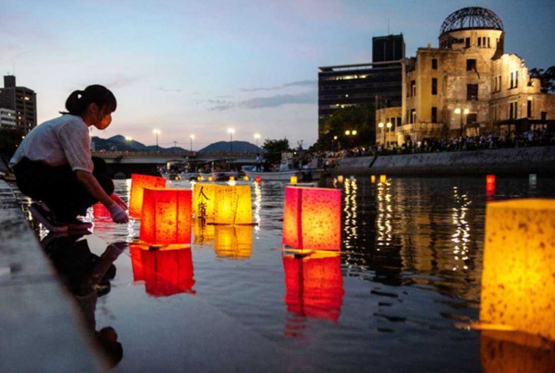 People release paper lanterns on the Motoyasu River beside the Hiroshima Prefectural Industrial Promotion Hall, commonly known as the atomic bomb dome, to mark the 77th anniversary of the world's first atomic bomb attack in Hiroshima on Aug. 6, 2022