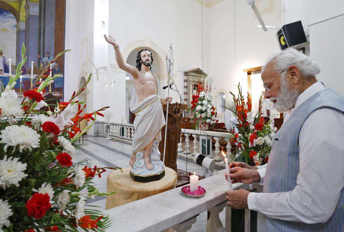 This handout photograph taken on April 9 and released by the Press Information Bureau (PIB) shows India's Prime Minister Narendra Modi lighting a candle at the Sacred Heart Cathedral Catholic Church on Easter Sunday, in New Delhi