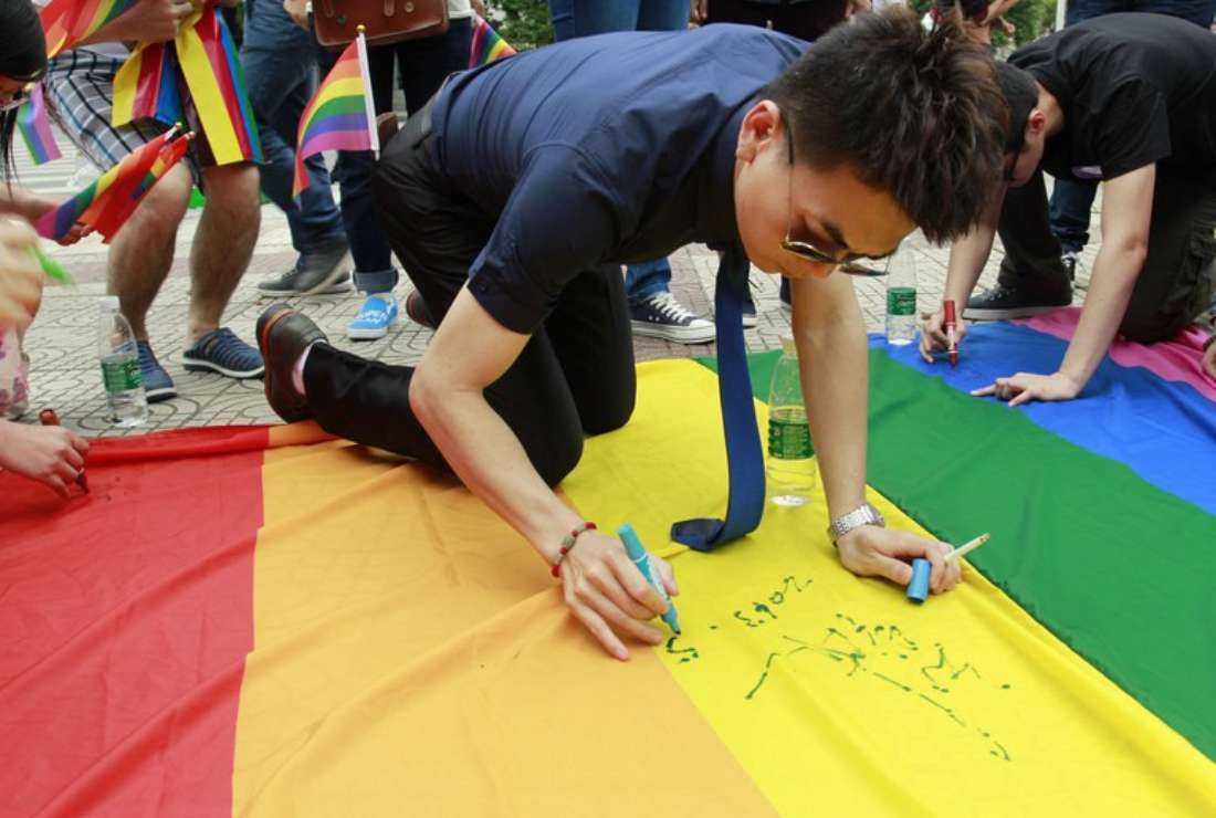 A man signs a rainbow flag during an anti-discrimination march in Changsha, China, in 2013. The ruling Chinese Communist Party currently regards LGBTQ+ rights activists as being influenced by 'hostile foreign forces' seeking to undermine its rule