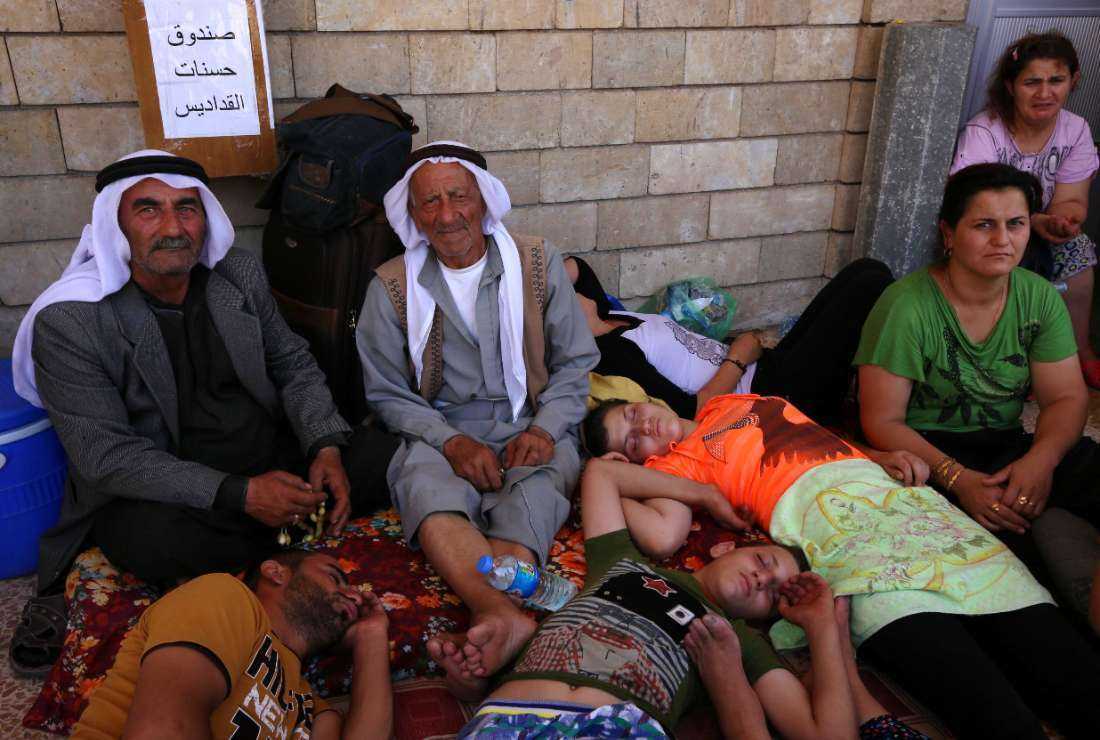 Iraqi Christians who fled the violence in the village of Qaraqush, about 30 kilometers east of the northern province of Nineveh, rest upon their arrival at the Saint-Joseph church in the Kurdish city of Arbil, in Iraq's autonomous Kurdistan region, on Aug. 7, 2014