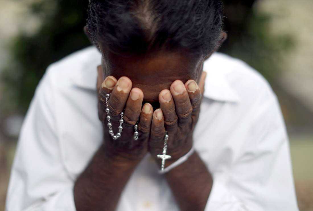A person mourns near the grave of a suicide bombing victim at Sellakanda Catholic cemetery April 23, 2019, in Negombo, Sri Lanka