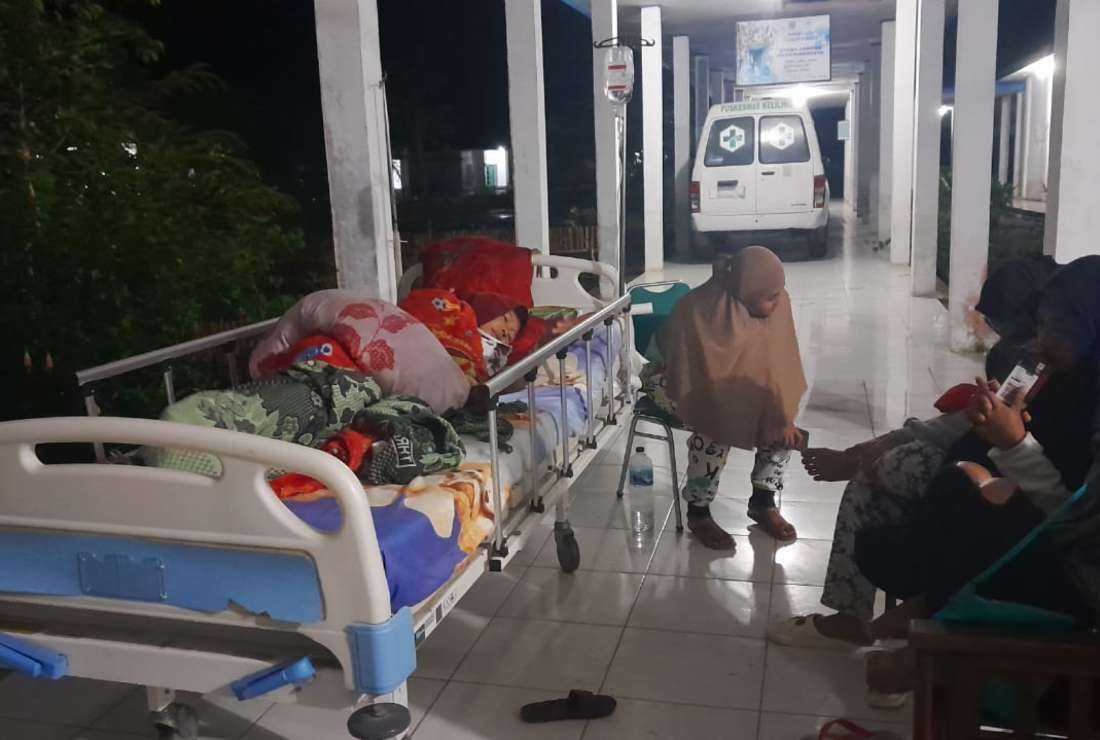 People stay outside of their houses and hospitals after a magnitude 7.1 earthquake occurred in their area in Muara Sikabaluan village, on Siberut Island on April 25