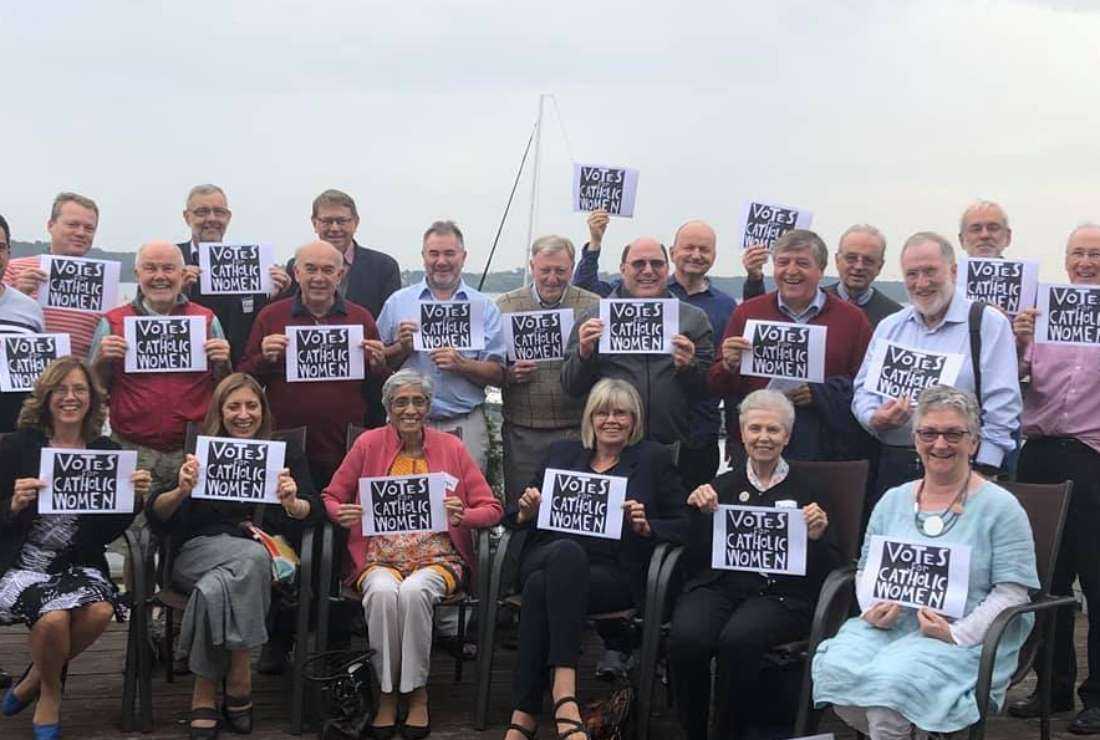 Catholic men and women demonstrate holding placards that read 'Votes for Catholic Women' during a meeting of the International Catholic Reform Network in Warsaw in 2019