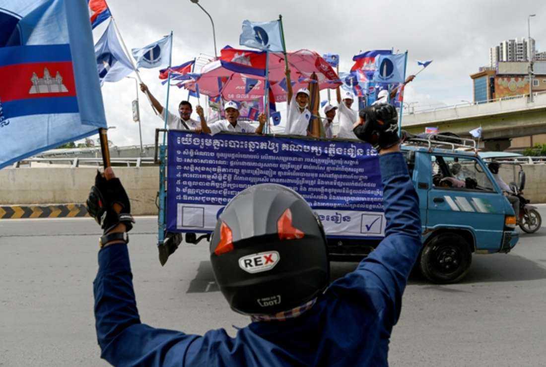 Supporters of the Candlelight Party shout slogans from a vehicle during a rally for the commune elections in Phnom Penh on June 3, 2022