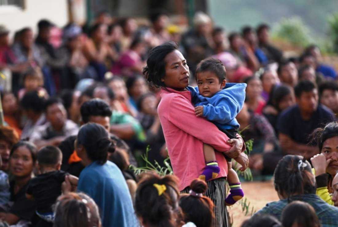 People wait at a temporary shelter in a military camp, after being evacuated by the Indian army, as they flee ethnic violence that has hit the northeastern Indian state of Manipur on May 7