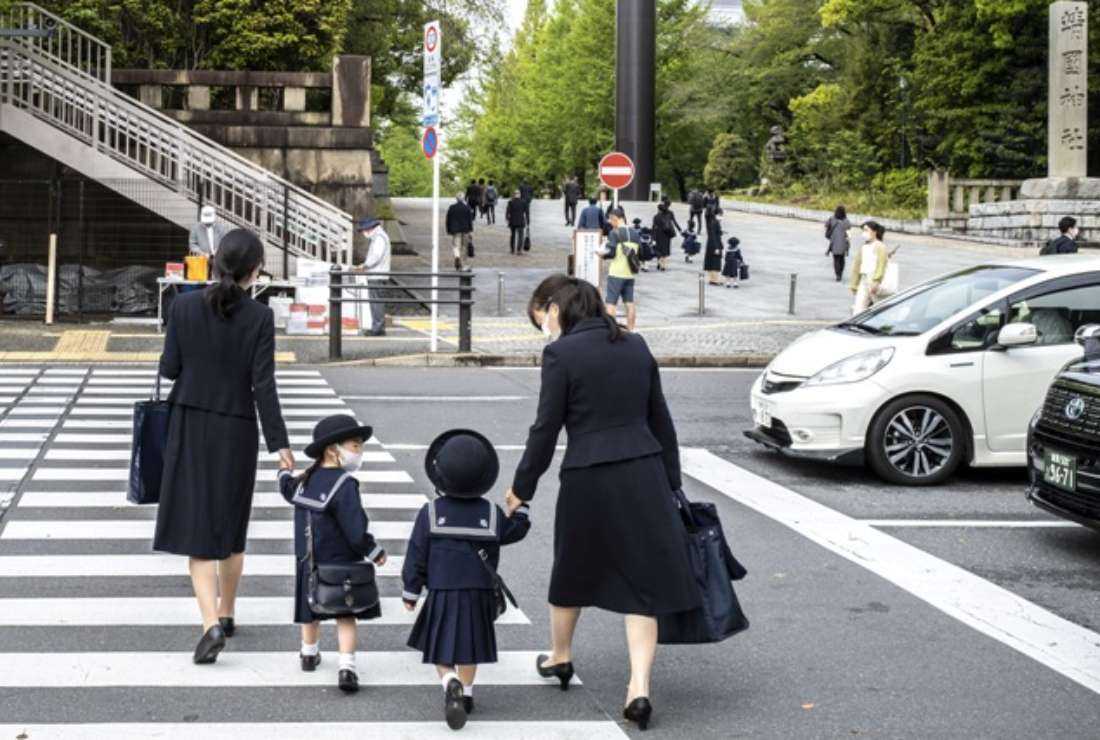 Japanese parents and pupils are pictured on the way to school in Tokyo on April 22, 2022