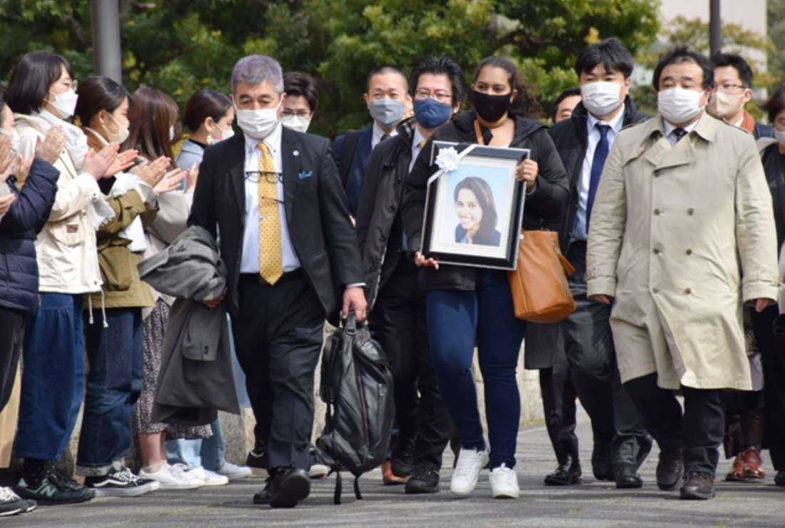The sister of a Sri Lankan woman, Wishma Sandamali, who died while in Japanese immigration detention, carries a picture of her late sister as she walks to the Nagoya District Court on March 4, 2022, to file a lawsuit against the government of Japan