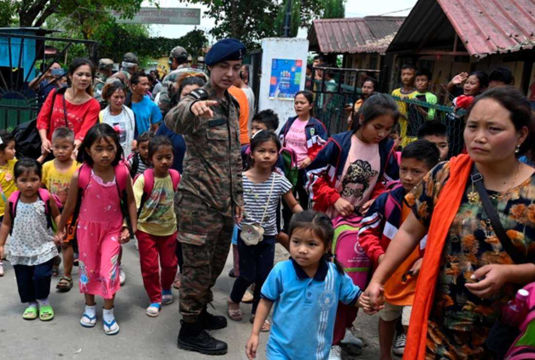 Children evacuated by the Indian army during the ethnic riots in Manipur state prepare to leave after reuniting with their parents at a temporary shelter at the Leimakhong Army Cantonment in the northeastern Indian state of Manipur on May 10