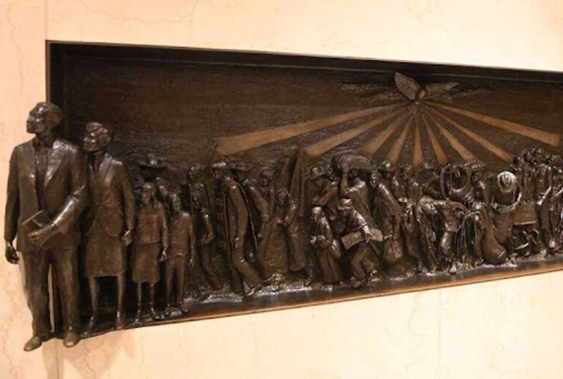 A bas relief sculpture seen Sept. 17, 2022, on the wall of the Our Mother of Africa Chapel at the Basilica of the National Shrine of the Immaculate Conception in Washington, depicts the African American experience from slavery to emancipation and the civil rights movement. The figures are guided by the Holy Spirit, seen above in the form of a dove, as they march toward Jesus on the cross, symbolizing ultimate freedom