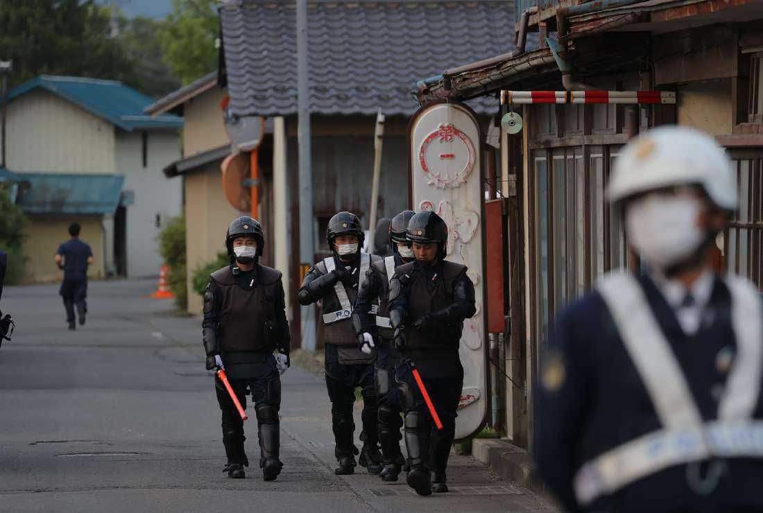 Police officers are seen near the scene of a standoff where a suspect, believed to be a farmer in his 30s, was holed up inside a building in the Ebe area of Nakano, Nagano Prefecture, early morning on May 26