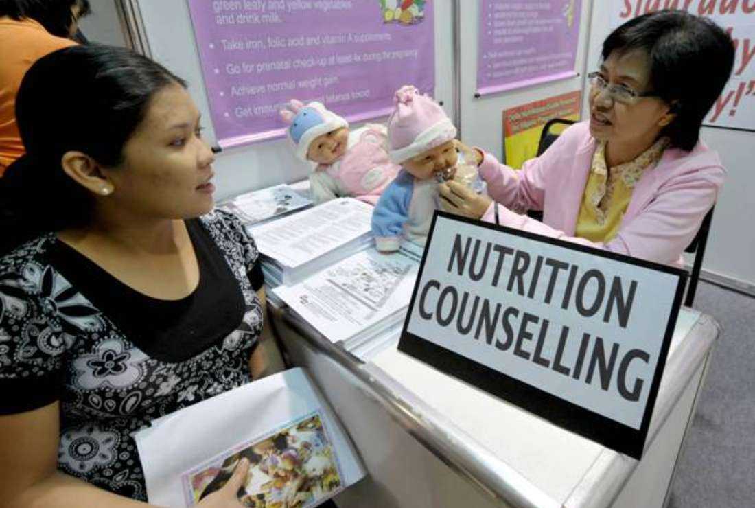 A health worker advises on nutrition to a pregnant mother at the 'Buntis Congress' (pregnant women congress) in Manila on July 13, 2008, in a gathering to promote responsible parenting and proper nutrition. Maternal mortality in the Philippines is often linked to poverty and lack of facilities, studies show