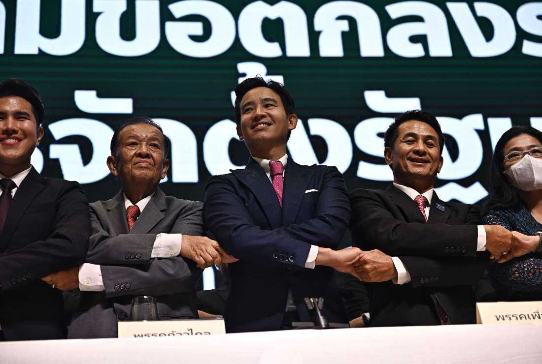 Move Forward Party leader and prime ministerial candidate Pita Limjaroenrat (center) joins hands with coalition partners at the signing ceremony for a memorandum of understanding (MOU) amongst eight Thai political parties in agreement to form a new government, in Bangkok on May 22