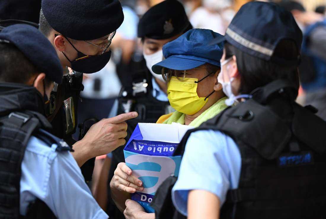 Police question a woman as she holds blank sheets of paper in the Causeway Bay district of Hong Kong on June 4, 2022, close to the venue where Hong Kongers have traditionally gathered to mourn victims of China's 1989 Tiananmen Square crackdown, on the 33rd anniversary of the incident. Hong Kong authorities strove to stop any public commemoration of the 33rd anniversary of the Tiananmen crackdown, with police warning gatherings could break the law as Beijing vies to remove all reminders of the events of June 4
