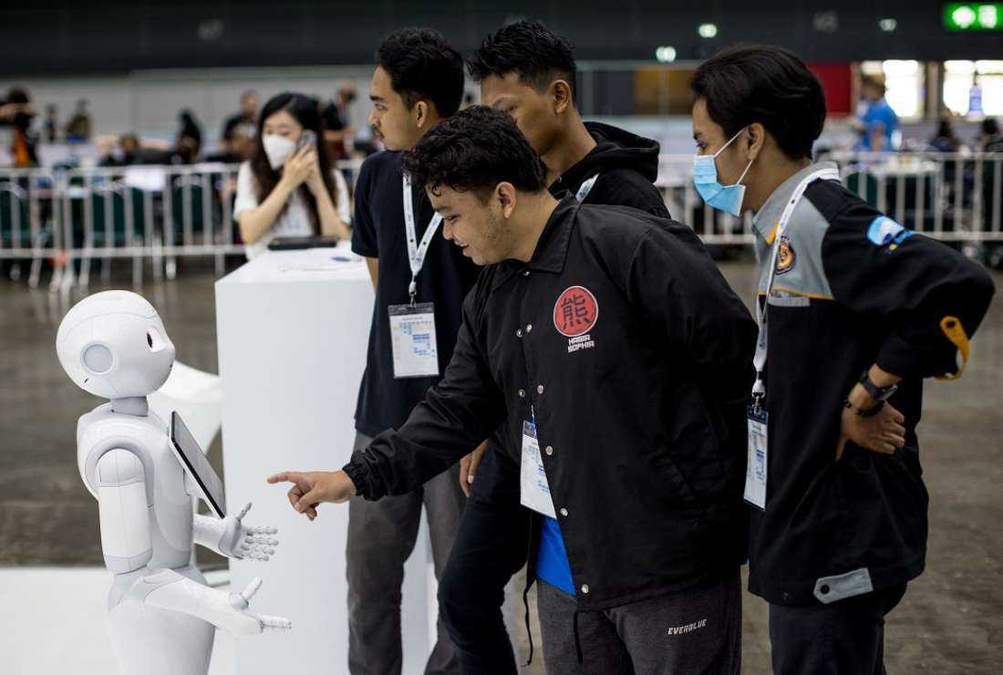 Visitors interact with a robot on display at RoboCup 2022, a robotics and Artificial Intelligence (AI) event in Bangkok on July 16, 2022