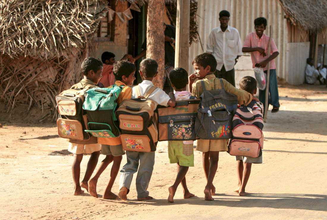 A group of children are pictured walking with school bags on their backs