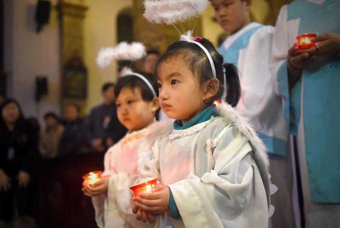 Young Chinese Catholics attend the Christmas Eve mass at a Catholic church in Beijing on December 24, 2015