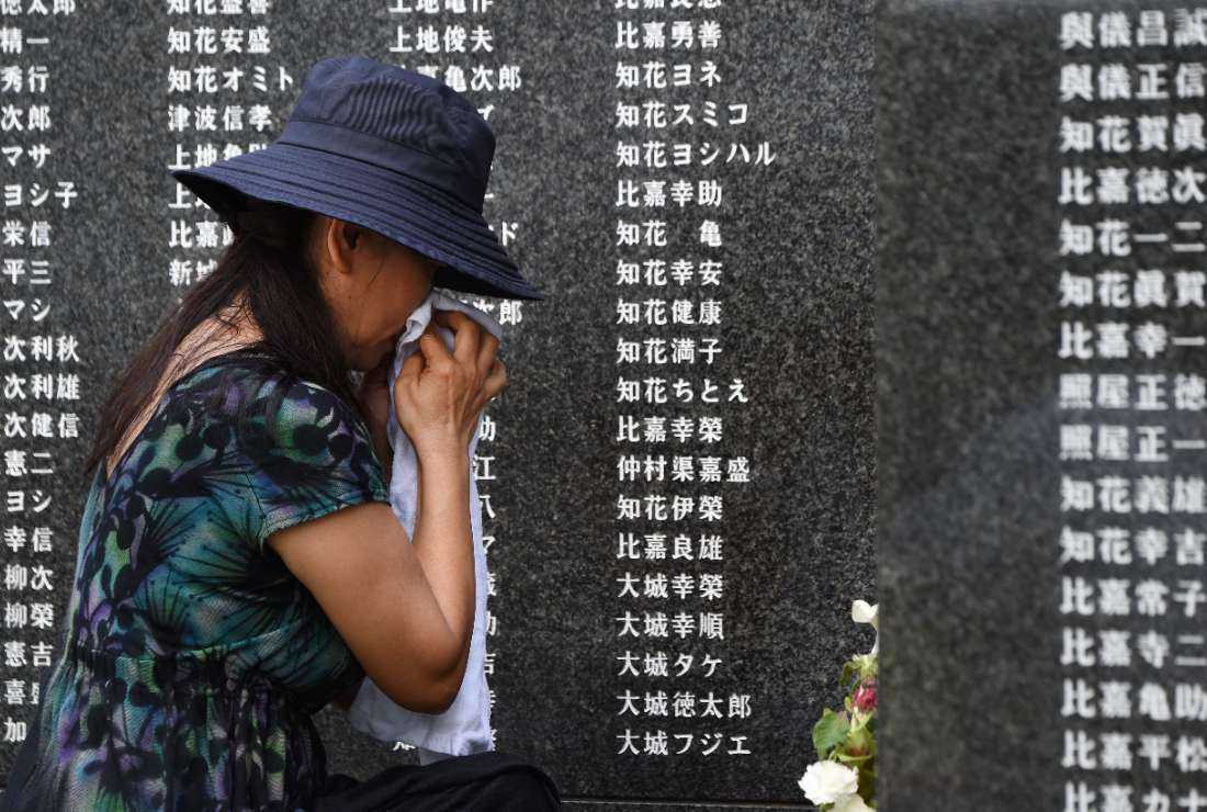 A woman wipes tears in front of a monument commemorating those who died in the battle of Okinawa during World War II at the Peace Memorial Park in Itoman, Japan's southern islands prefecture of Okinawa, on June 23, 2015