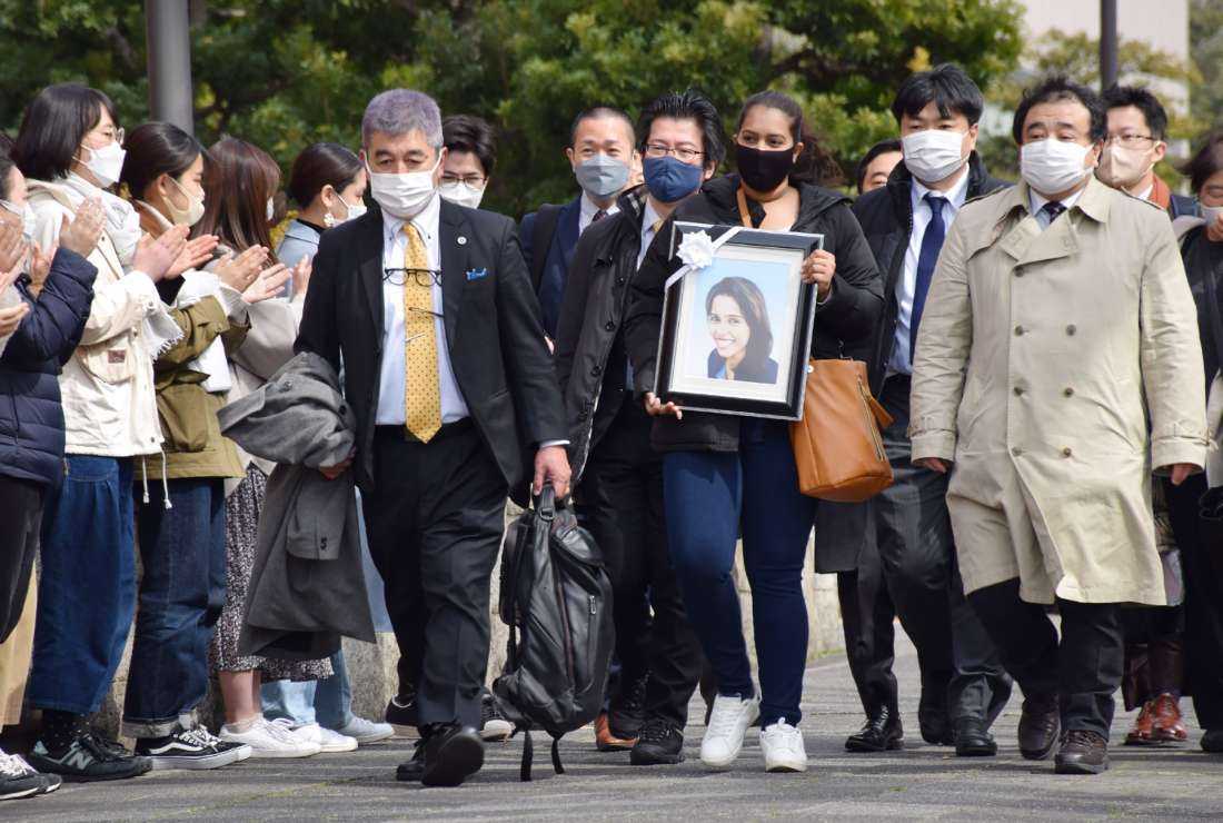 The sister of a Sri Lankan woman, Wishma Sandamali, who died while in Japanese immigration detention, carries a picture of her late sister as she walks to the Nagoya district court on March 4, 2022, to file a lawsuit against the government of Japan