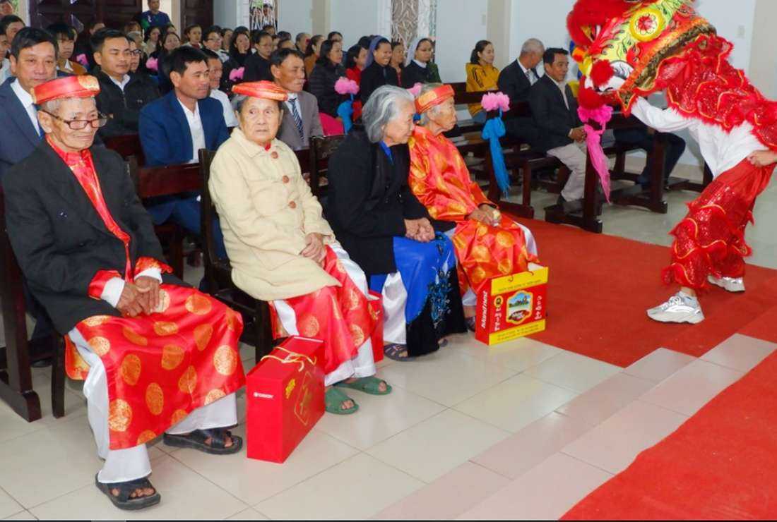 Elderly people in traditional costumes are honored with gifts and lion dances at My Chanh Church in Vietnam on Jan. 21, 2023