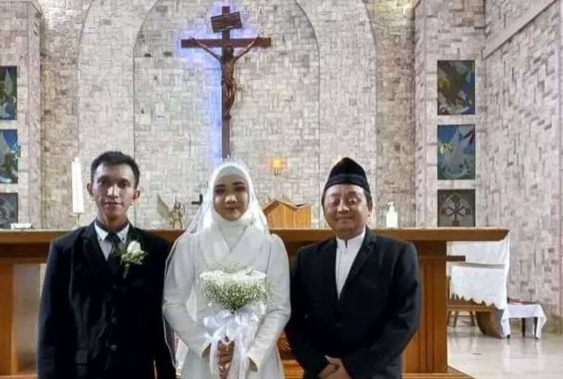 Ahmad Nurcholish, an interfaith marriage counselor with Indonesian Conference on Religion and Peace, poses for a photo session with an interfaith couple in this file image